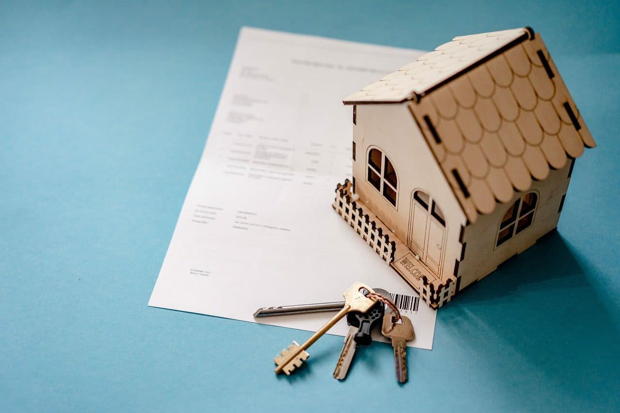 réplique d'une maison sur un contrat et des clefs